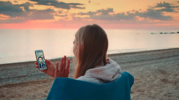 Jeune femme faisant un appel vidéo avec smartphone sur le bord de la mer — Photo