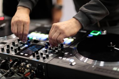 DJ, profesyonel bir MIDI kontrolöründe şarkıları karıştırıyor. Seçici odak.