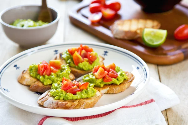 Crostini met avocado en tomaat — Stockfoto