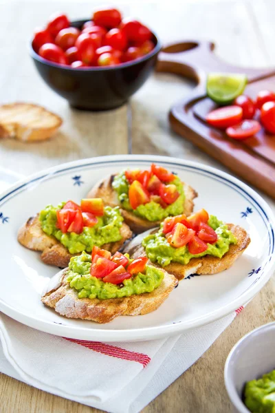 Crostini met avocado en tomaat — Stockfoto