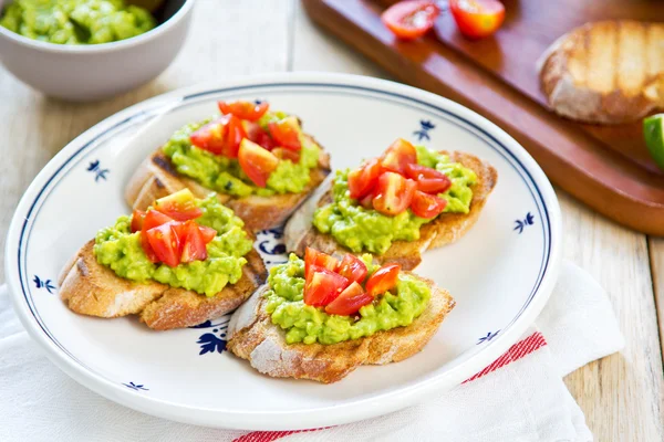 Crostini met avocado en tomaat — Stockfoto