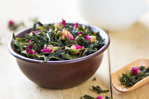 Green tea leaves with rose buds — Stock Fotó