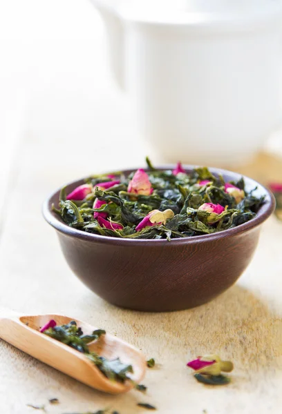 Green tea leaves with rose buds — Stockfoto