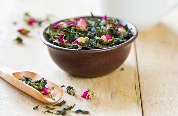 Green tea leaves with rose buds — Stockfoto