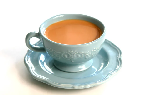 Tea with milk in blue cup and sauce — Stock Photo, Image