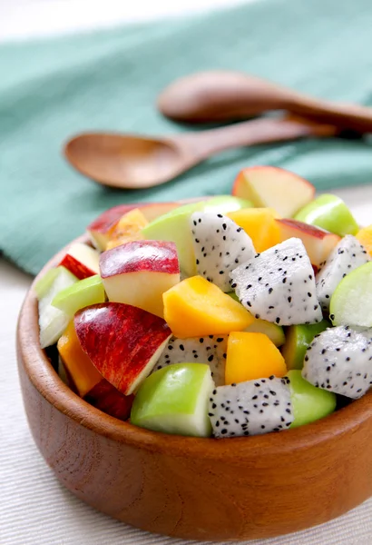 Variedad de ensalada de frutas en un tazón de madera — Foto de Stock