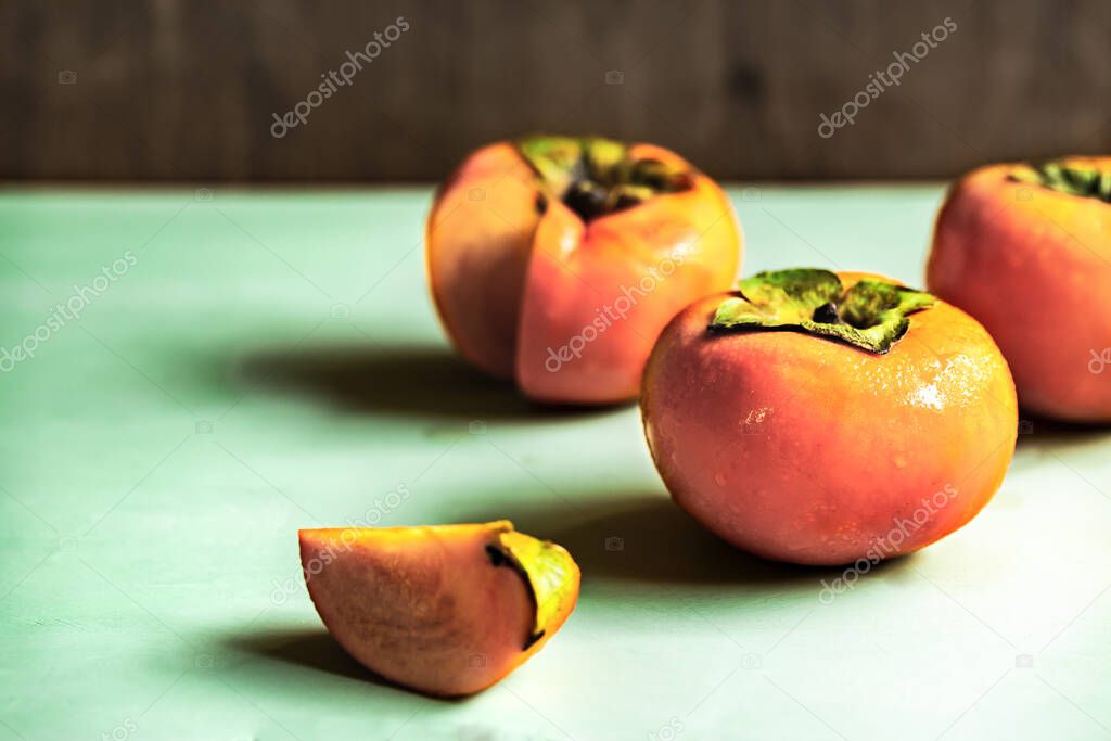 Fresh Persimmons  on green woodboard