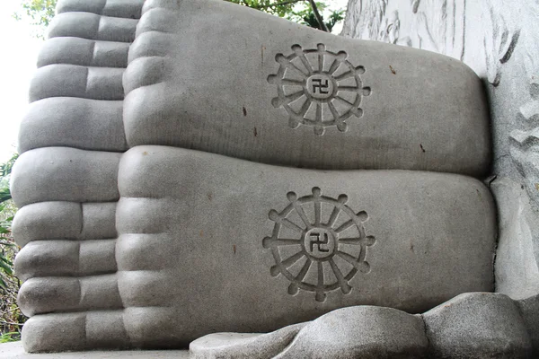 Feet of a sleeping buddha, decorated with a swastika — Stock Photo, Image