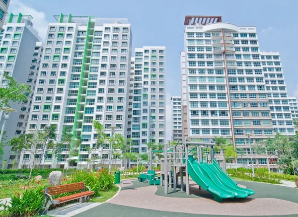 Parque infantil dentro da propriedade residencial de arranha-céus — Fotografia de Stock