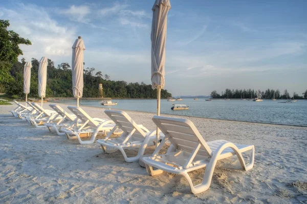 Sedie a sdraio e ombrelloni in spiaggia — Foto Stock