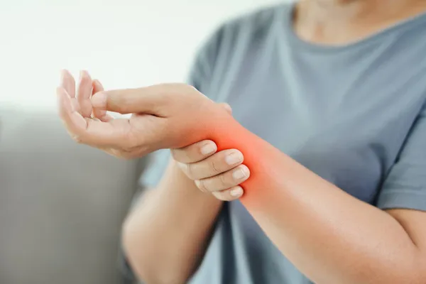 Closeup Woman Sitting Sofa Holds Her Wrist Hand Injury Red — Stock Photo, Image