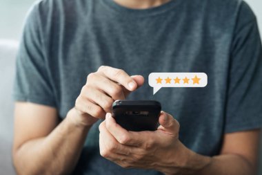 Müşterinin akıllı telefondan 5 yıldızlı reyting vermesine yakın çekim. İnceleme, Hizmet derecesi, memnuniyet, Müşteri hizmetleri deneyimi ve memnuniyet anketi konsepti