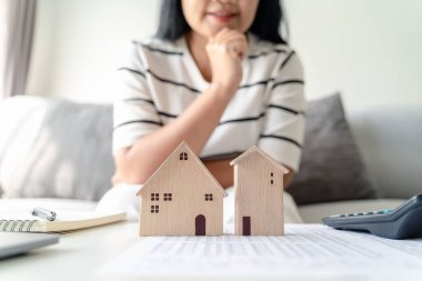 Kadın, Küçük Ahşap Ev Modeli 'yle ev seçmeye karar veriyor. Mülk almayı planlıyor. En iyi olanı seç. konut kredisi kavramları
