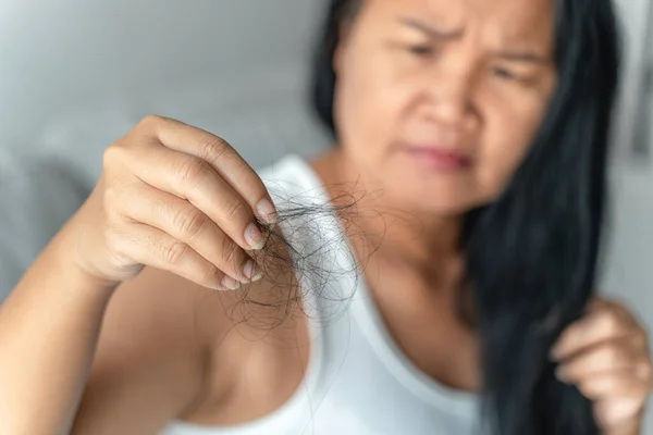 Asian woman with hair fall problem. Hair care and beauty concepts