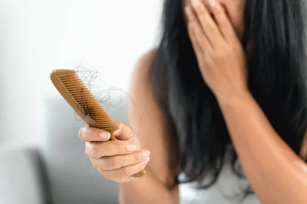 Hair fall problem. Asian woman with comb and hair problem. Hair loss from comb. Hair care and beauty concepts.