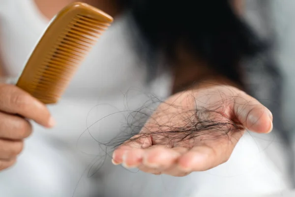 Hair fall problem. Asian woman with comb and hair problem. Hair loss from comb. Hair care and beauty concepts.