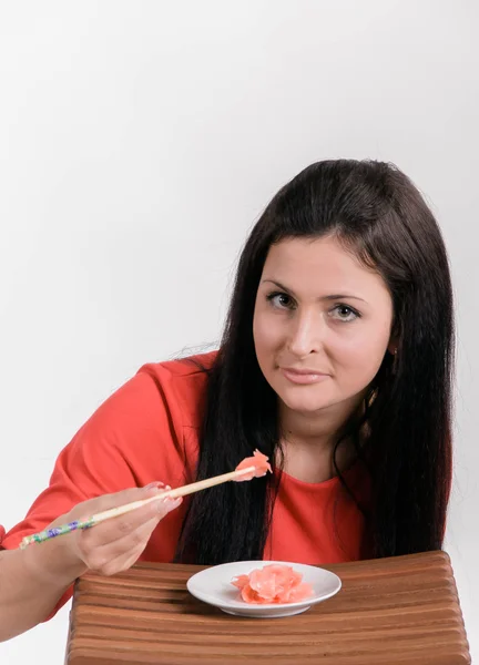 Girl eating ginger — Stock Photo, Image