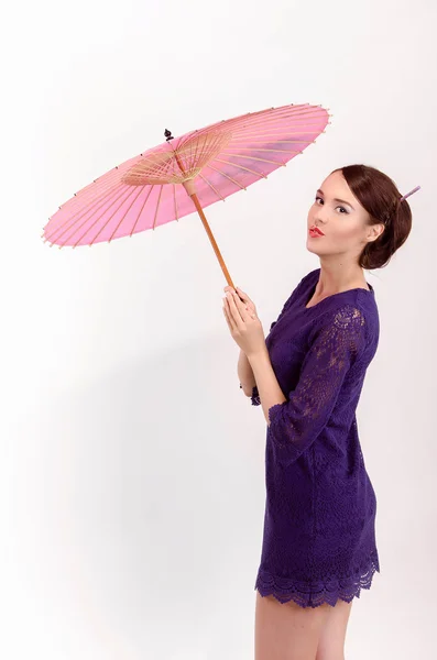 Japanisches Mädchen mit einem rosa Regenschirm — Stockfoto