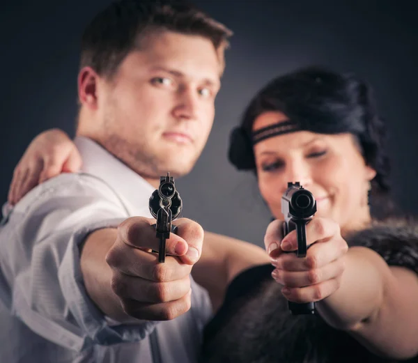 Girl and guy with pistols — Stock Photo, Image