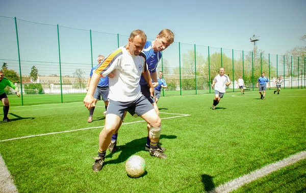 Uomini che giocano a calcio Immagine Stock