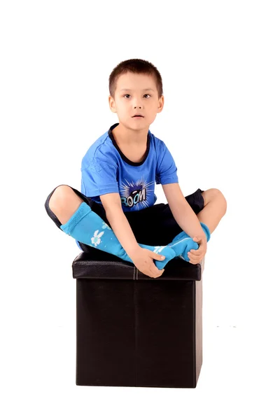 Junge sitzt auf Pufe — Stockfoto