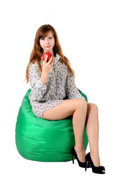 Chica con una manzana sentada en un pufe verde — Foto de Stock