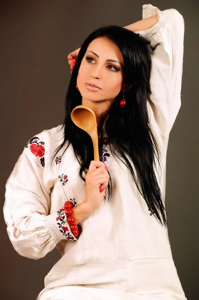 Flicka klädd i ukrainska stil och en trä sked — Stockfoto