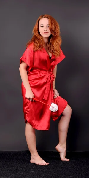 Рыжая девушка в халате и с кисточками в руке — стоковое фото