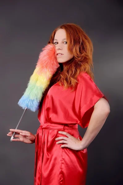 Barefoot red-haired girl in a bathrobe and with a color brush — Stock Photo, Image