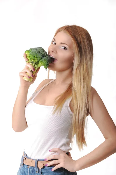 Chica mordiendo brócoli — Foto de Stock