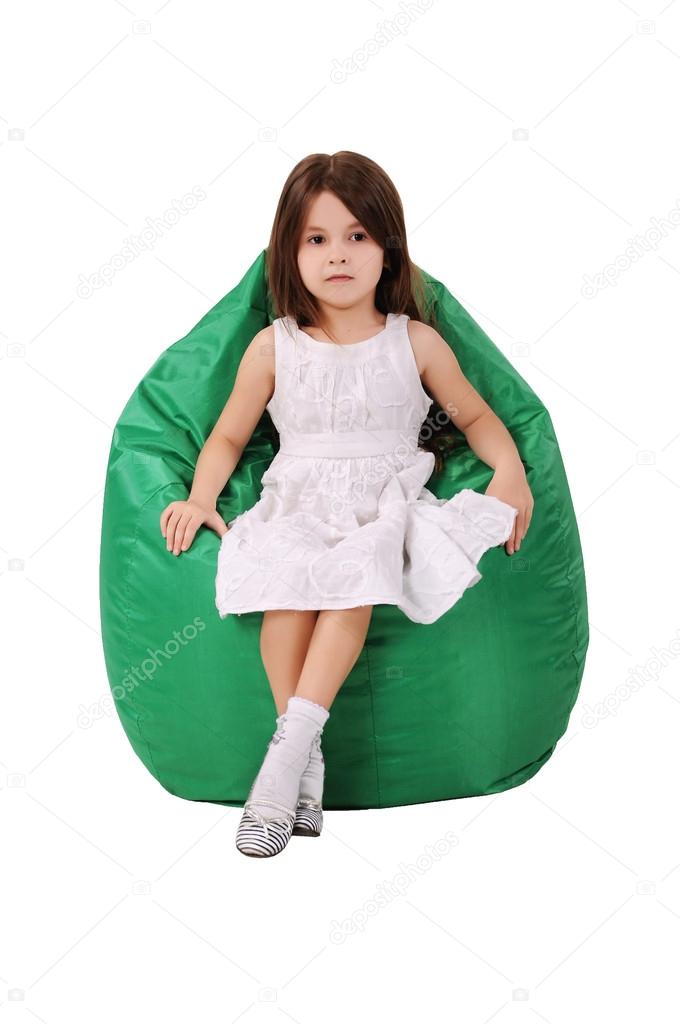 Little girl sits on a green pufe, advertising