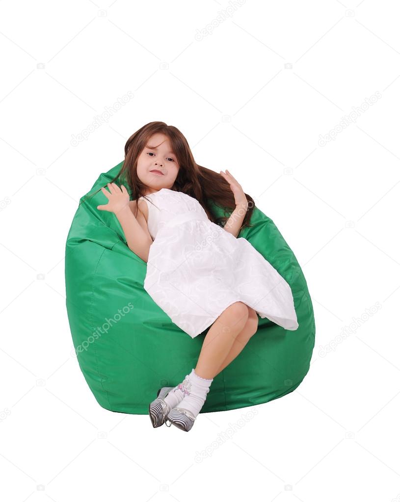 Little girl sits on a pufe
