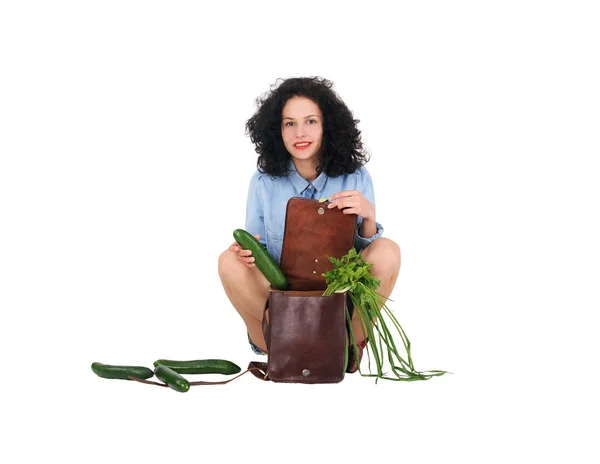 Meisje trekt uit de zak komkommer, witte achtergrond — Stockfoto