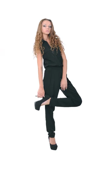 Girl in a black suit stands on one leg — Stock Photo, Image