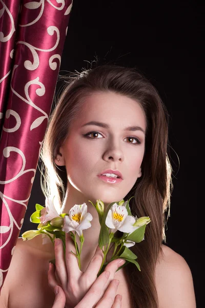 Hermosa cara de mujer con una flor — Foto de Stock