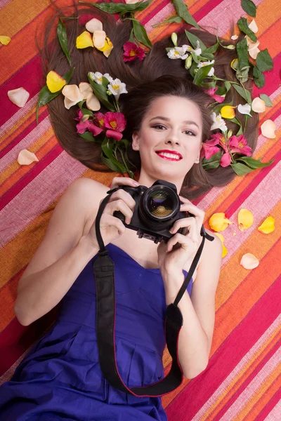 Mulher bonita com uma flor e câmera — Fotografia de Stock