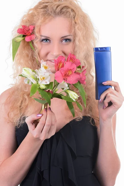 Schönes Frauengesicht mit einer Blume und Shampoo-Flasche — Stockfoto