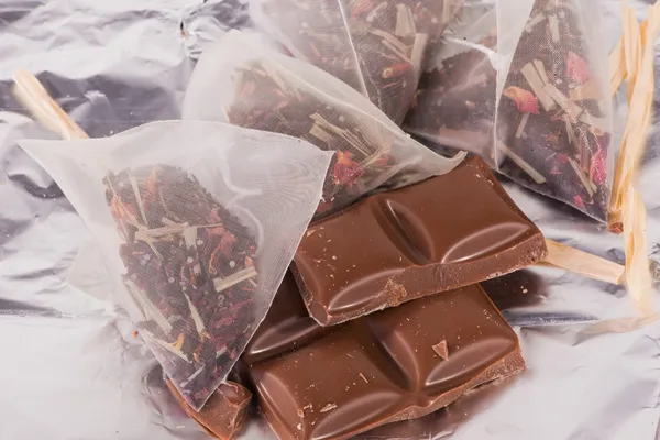 Kousky čokolády a čajové sáčky — Stock fotografie