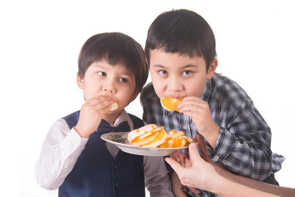 Мальчики едят апельсин — стоковое фото
