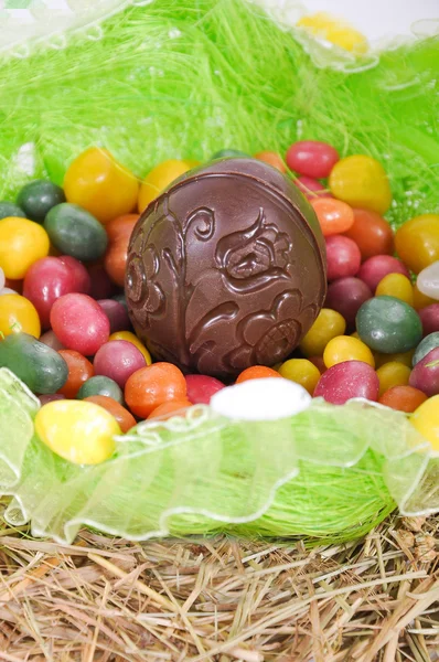 Kleurrijke paaseieren en chocolade ei in een mand — Stockfoto