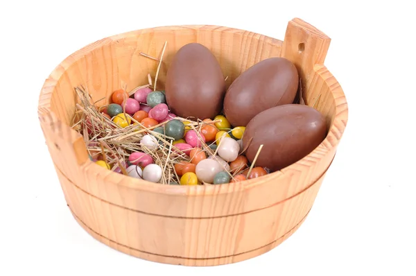 Ovos de páscoa coloridos e ovos de chocolate em uma cesta — Fotografia de Stock