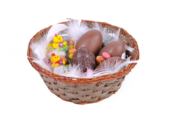 Kolorowe pisanki i czekoladowe jajka w koszyku — Zdjęcie stockowe