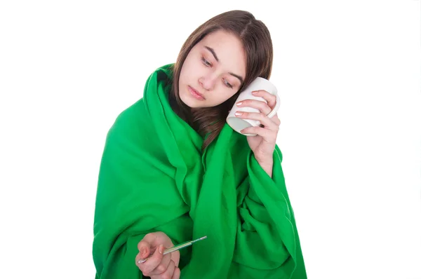 Нездоровая женщина, покрытая одеялом, держит чашку чая — стоковое фото