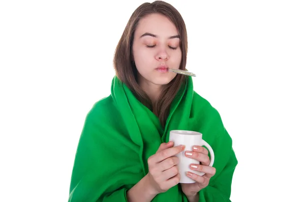 Sjuk kvinna täckt med filt håller en te-kopp — Stockfoto