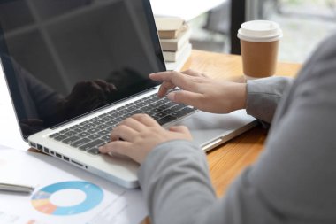 İş kadınının eli bilgisayarla klavyeye basıyor, finansal işlemleri yürütmek için bilgisayarları kullanıyor çünkü kolaylık ve hız, teknoloji ve internet iletişimi dünyası.