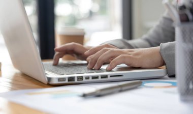 İş kadınının eli bilgisayarla klavyeye basıyor, finansal işlemleri yürütmek için bilgisayarları kullanıyor çünkü kolaylık ve hız, teknoloji ve internet iletişimi dünyası.