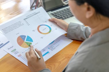 Asyalı iş kadınları grafikleri, mali istatistikleri ve özel ofislerdeki kurumsal getirileri, piyasa araştırma raporlarını ve gelir istatistiklerini, Mali ve Muhasebe kavramını analiz ediyorlar..