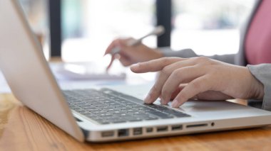 İş kadınının eli bilgisayarla klavyeye basıyor, finansal işlemleri yürütmek için bilgisayarları kullanıyor çünkü kolaylık ve hız, teknoloji ve internet iletişimi dünyası.