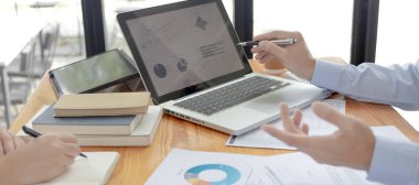 Beyin fırtınası ekibi, pazarlamacılar ve finans muhasebecileri müşteri ihtiyaçlarını karşılamak için stratejiler planlamak, grafikler ve dizüstü bilgisayarları kullanarak iş verilerini analiz etmek ve konsepti karşılamak için grafikleri tartışıyor ve analiz ediyorlar..