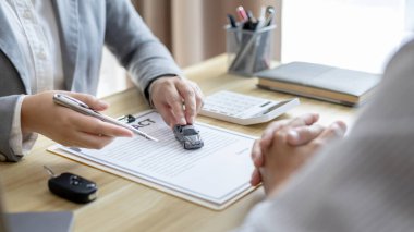 Selling cars, Car dealership or sales manager offers the sale of a car and explains the terms of signing a car purchase and insurance contract, Finance and after-sales service concept. 	